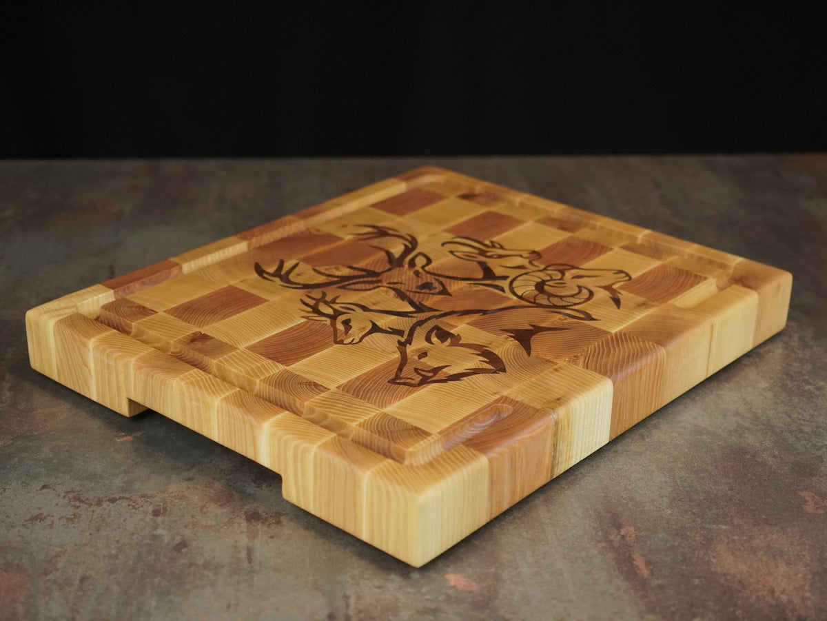 La Sauvage, planche à découper en frêne et bois de bout avec incrustation noyer de têtes de cerf, sanglier, mouflon et chamois